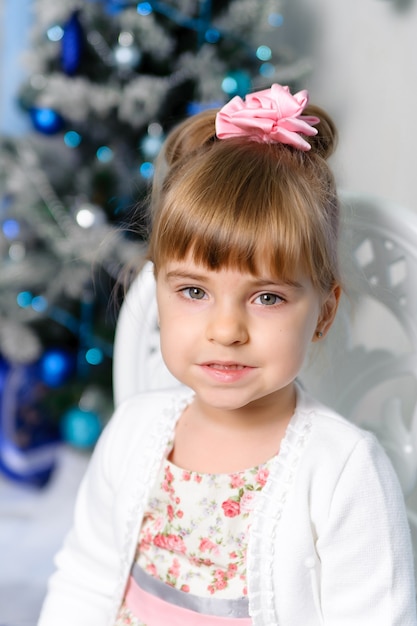 Bambina su sfondo albero di Natale.