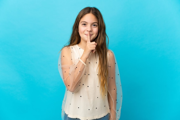 Bambina su sfondo blu isolato che mostra un segno di silenzio gesto mettendo il dito in bocca