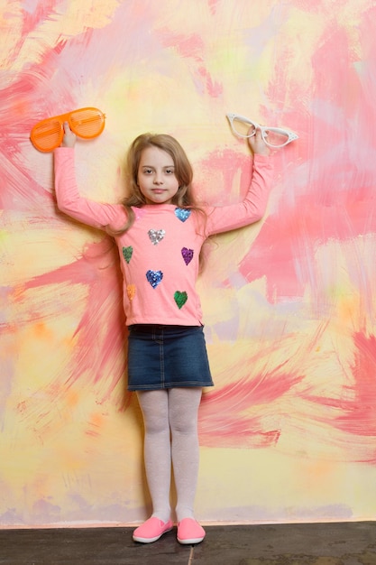 Bambina su sfondo colorato occhiali su ragazza bambino con viso carino Bambina con occhiali estivi alla moda Infanzia e felicità bellezza e moda