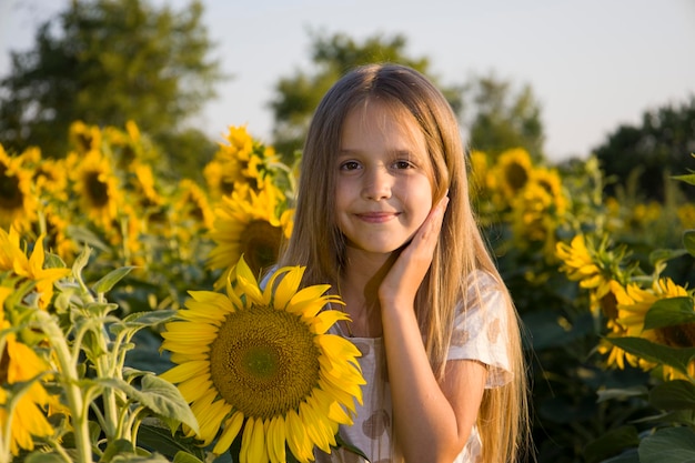 Bambina sul campo con girasoli sfocato sullo sfondo