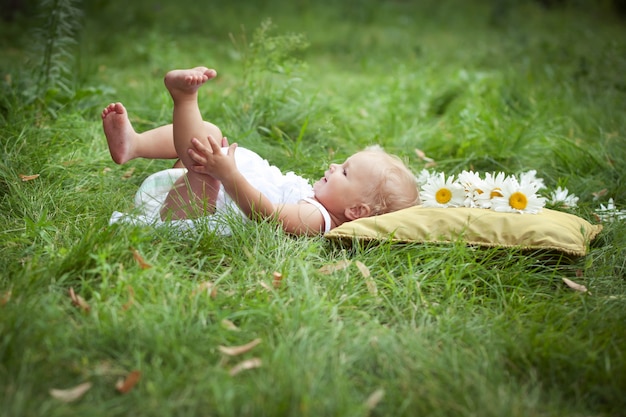 bambina sul morbido cuscino in erba fresca di primavera