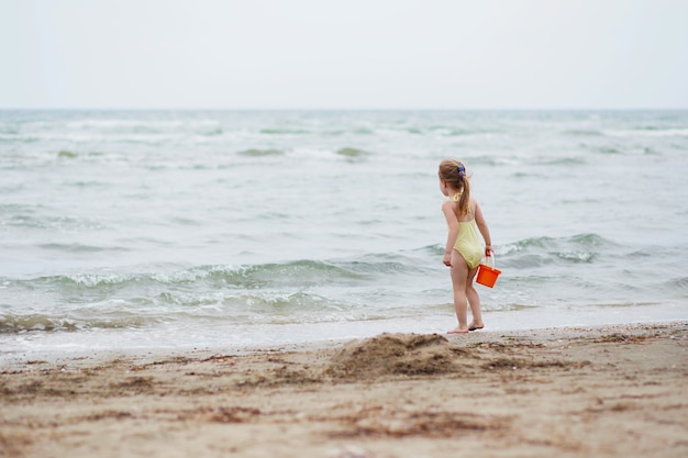 Bambina sulla spiaggia di sabbia famiglia mare vacanza