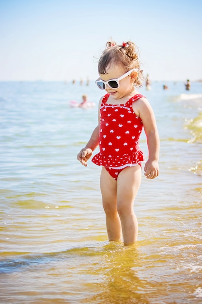 Bambina sulla spiaggia, in riva al mare. Messa a fuoco selettiva