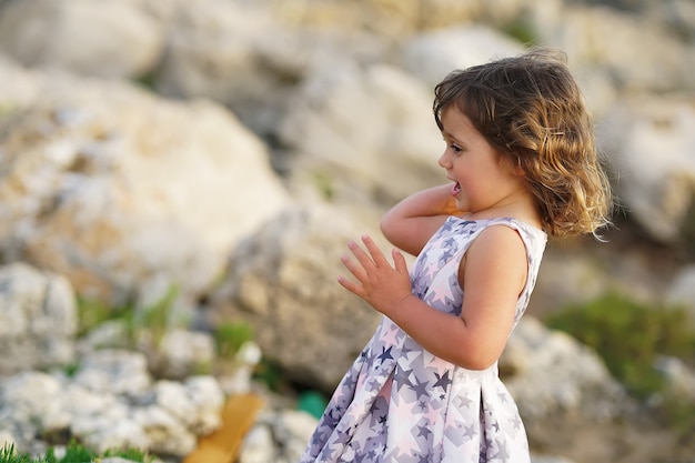 Bambina sullo sfondo delle rocce del Mediterraneo