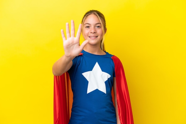 Bambina Super Hero isolata su sfondo giallo che conta cinque con le dita