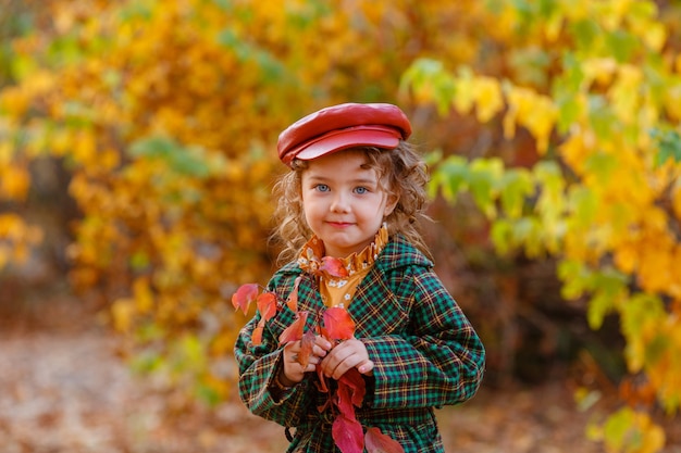 Bambina sveglia alla moda nel parco d'autunno