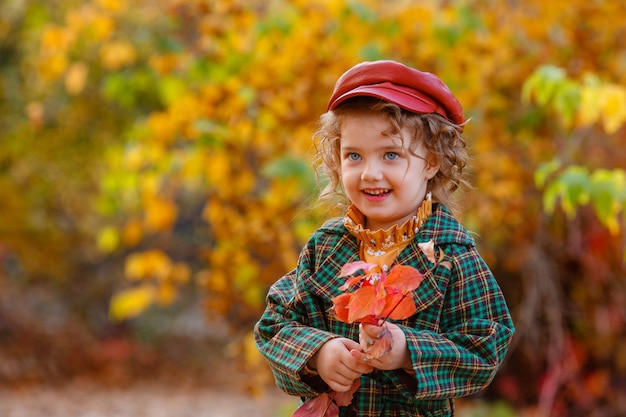 Bambina sveglia alla moda nel parco d'autunno