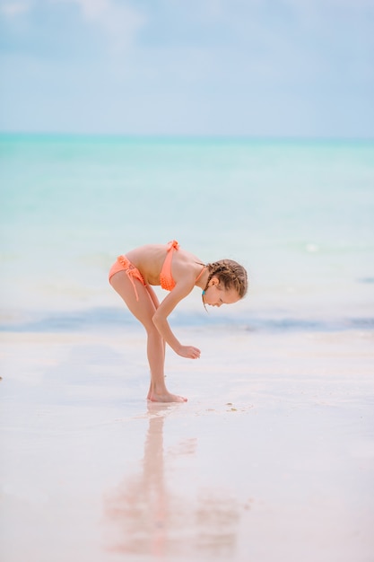 Bambina sveglia alla spiaggia durante la vacanza caraibica