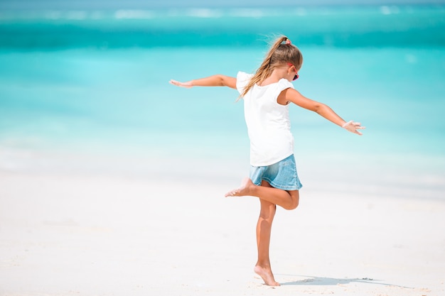 Bambina sveglia alla spiaggia durante la vacanza caraibica