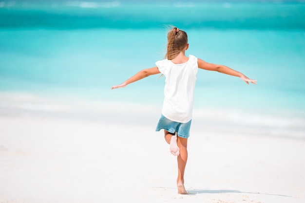 Bambina sveglia alla spiaggia durante la vacanza caraibica