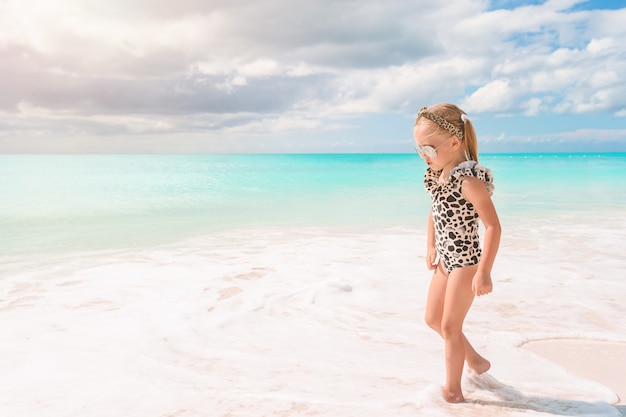 Bambina sveglia alla spiaggia durante la vacanza caraibica