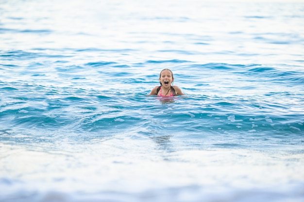 Bambina sveglia alla spiaggia durante la vacanza caraibica