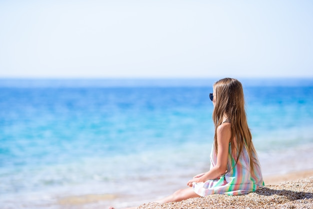 Bambina sveglia alla spiaggia durante le vacanze estive