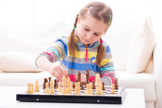 Bambina sveglia che gioca a scacchi