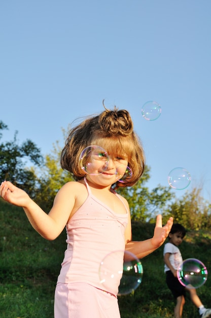 Bambina sveglia che gioca con le bolle di sapone