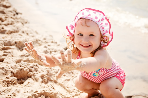 Bambina sveglia che gioca sulla spiaggia