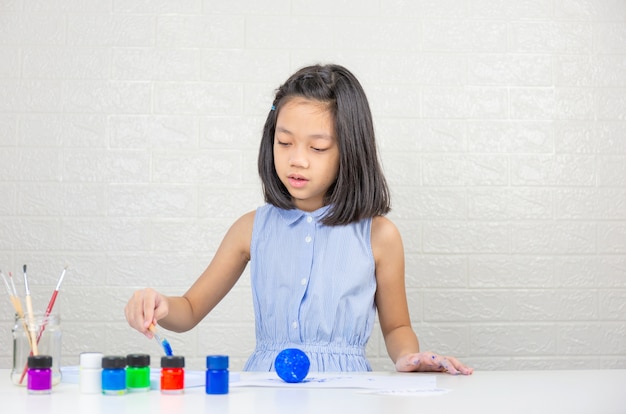 Bambina sveglia che impara con il colore della pittura sulla palla della schiuma