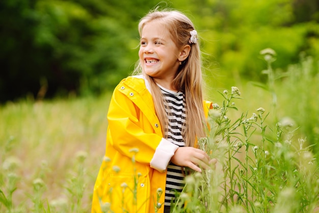 Bambina sveglia che raccoglie fiori di campo nel prato Un bambino esplora la natura