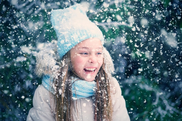 Bambina sveglia che ride e neve che cade