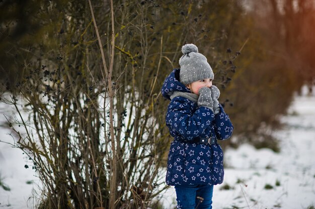 Bambina sveglia che si diverte all'aperto il giorno d'inverno.