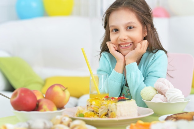 Bambina sveglia che si siede alla tavola