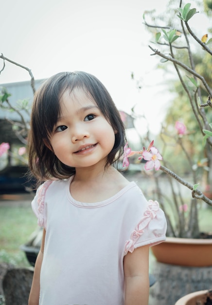 Bambina sveglia che sorride a casa giardino