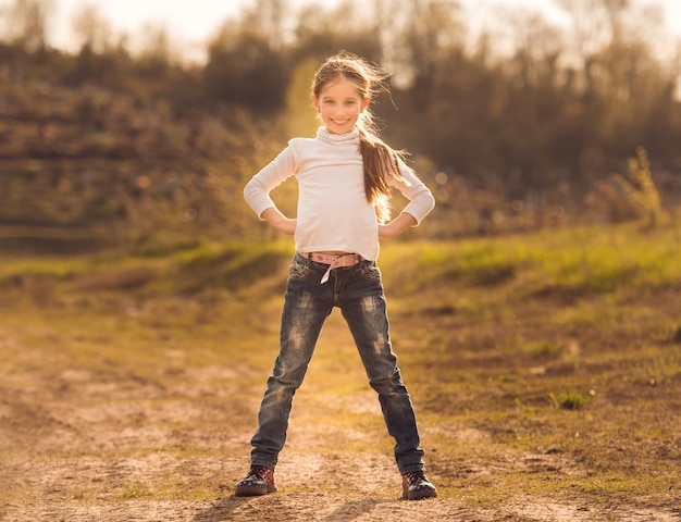 Bambina sveglia che sta su una strada