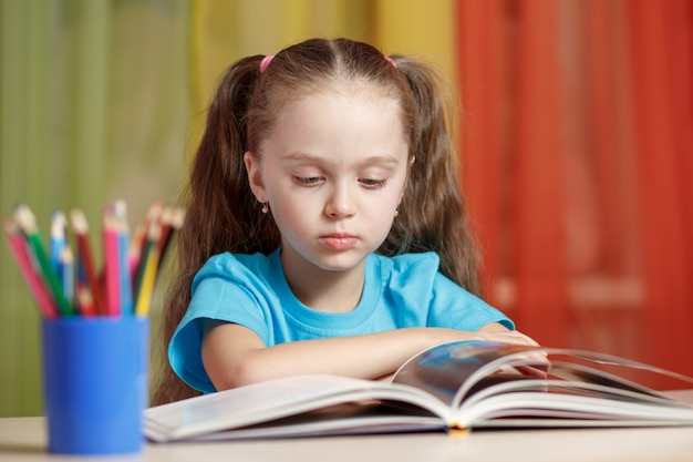 Bambina sveglia che studia a casa