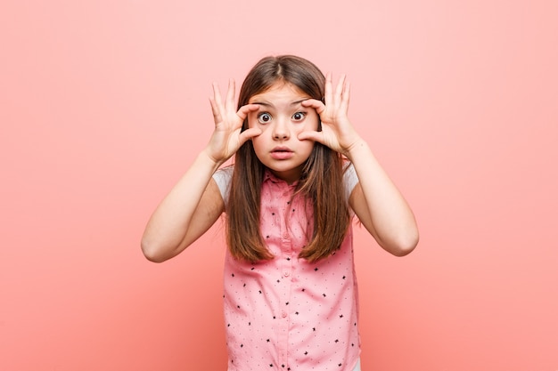 Bambina sveglia che tiene gli occhi aperti per trovare un'opportunità di successo.