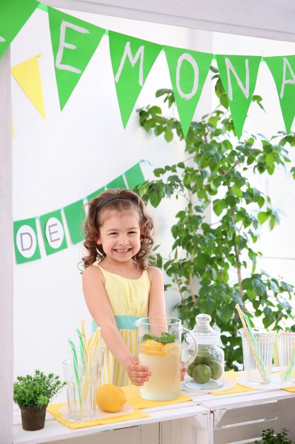 Bambina sveglia che vende limonata al bancone