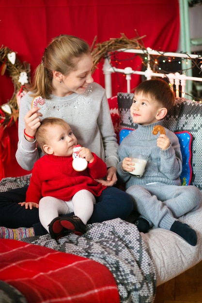 Bambina sveglia con i regali di Natale su legno