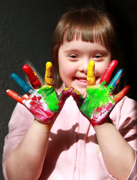 Bambina sveglia con le mani dipinte.