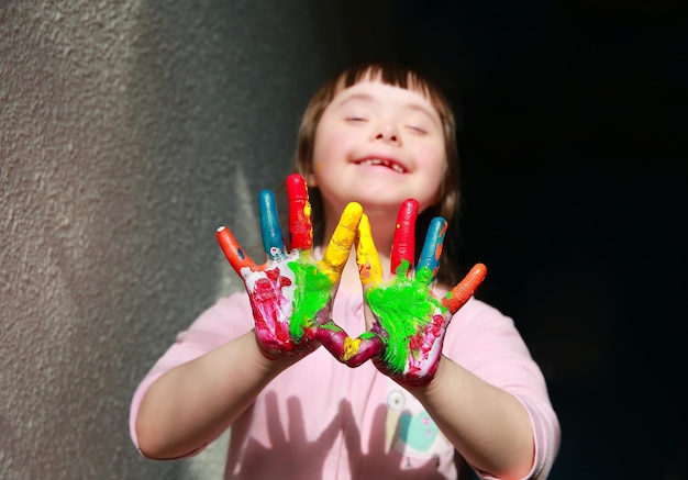 Bambina sveglia con le mani dipinte.