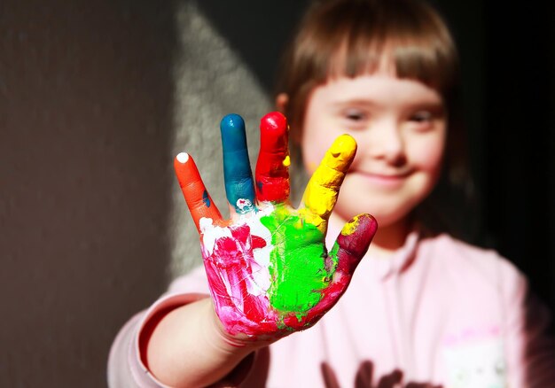 Bambina sveglia con le mani dipinte.