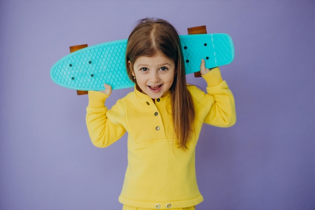 Bambina sveglia con lo skateboard in studio