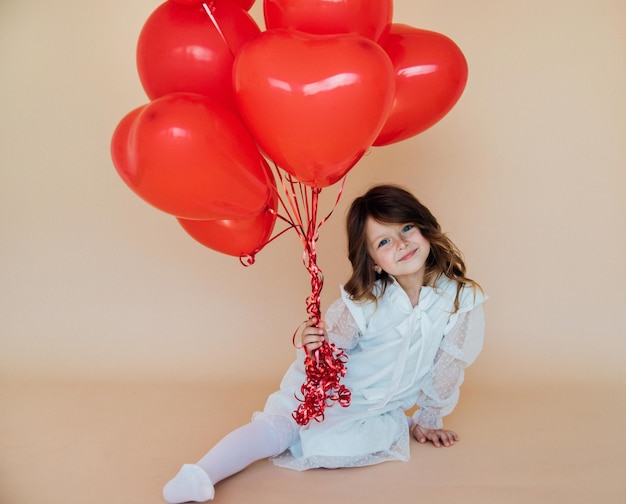 Bambina sveglia con palloncini a forma di cuore per San Valentino, regali di amore per la famiglia per le vacanze