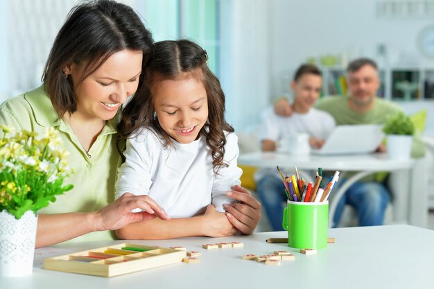 Bambina sveglia con sua madre che studia insieme nella stanza