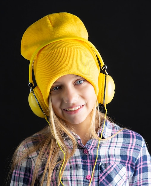 Bambina sveglia con un cappello e cuffie