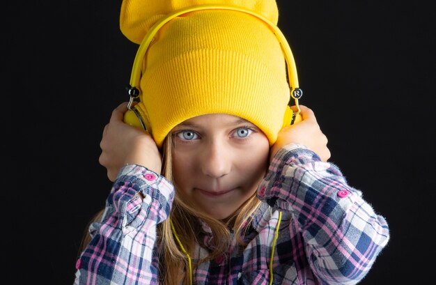 Bambina sveglia con un cappello e cuffie