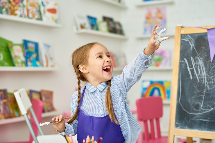 Foto bambina sveglia divertendosi con la pittura