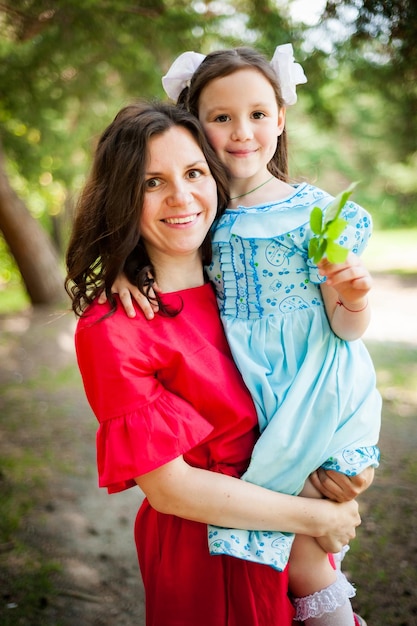 Bambina sveglia e sua madre che si divertono sull'erba in un Sunny Park