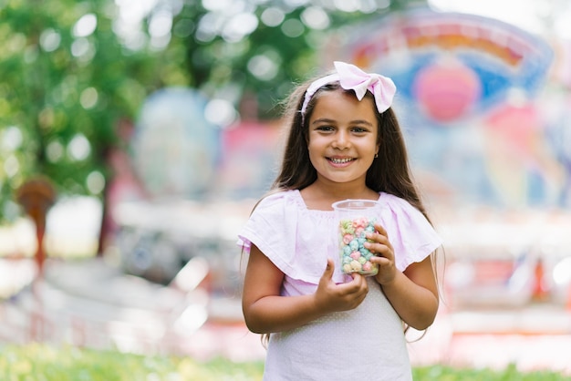 Bambina sveglia in estate nel parco che tiene il popcorn nelle sue mani