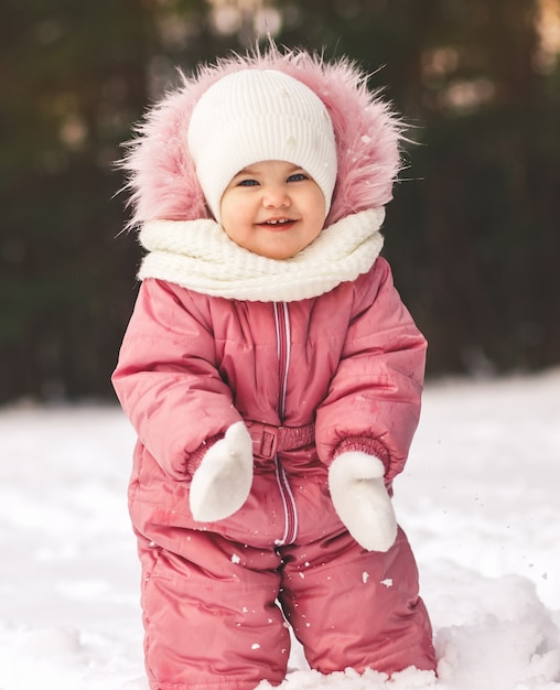 Bambina sveglia in inverno in una passeggiata nel parco. Verticale