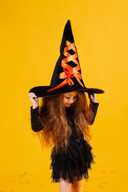 Bambina sveglia in un costume di Halloween della strega