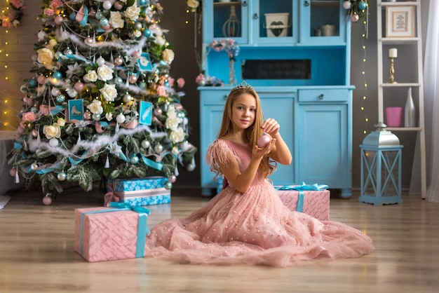 Bambina sveglia in un vestito rosa a Natale