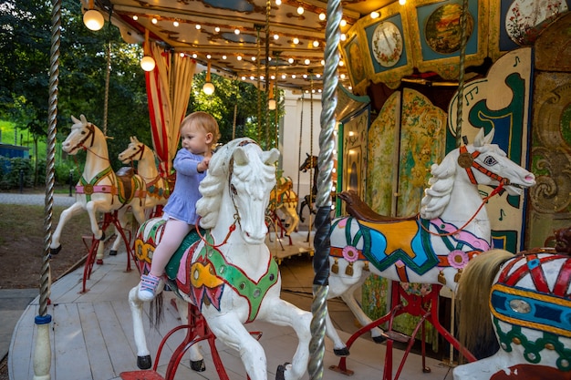 Bambina sveglia sul cavallo della vecchia giostra retrò praga repubblica ceca