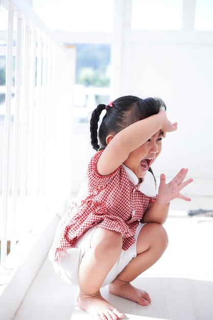 Bambina triste seduta sul pavimento in una stanza vuota