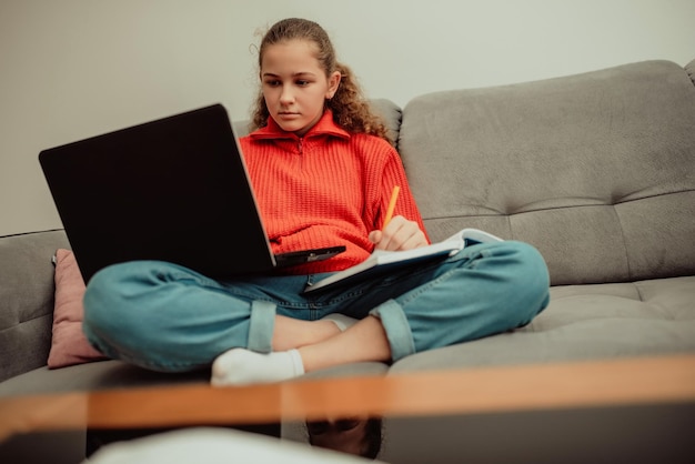 Bambina un bambino in età prescolare utilizza un computer portatile per studiare a casa il bambino sorride felice e riceve la conoscenza in remoto concetto digitale di elearning elearning a distanza