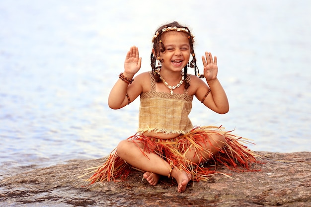 Bambina vestita come un indigeno all'aperto in estate. Foto di alta qualità