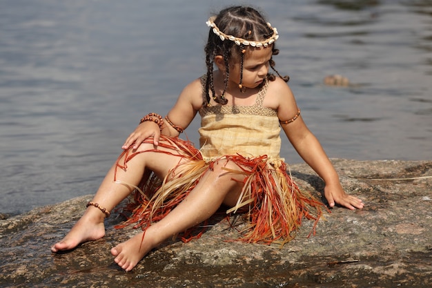 Bambina vestita come un indigeno all'aperto in estate. Foto di alta qualità